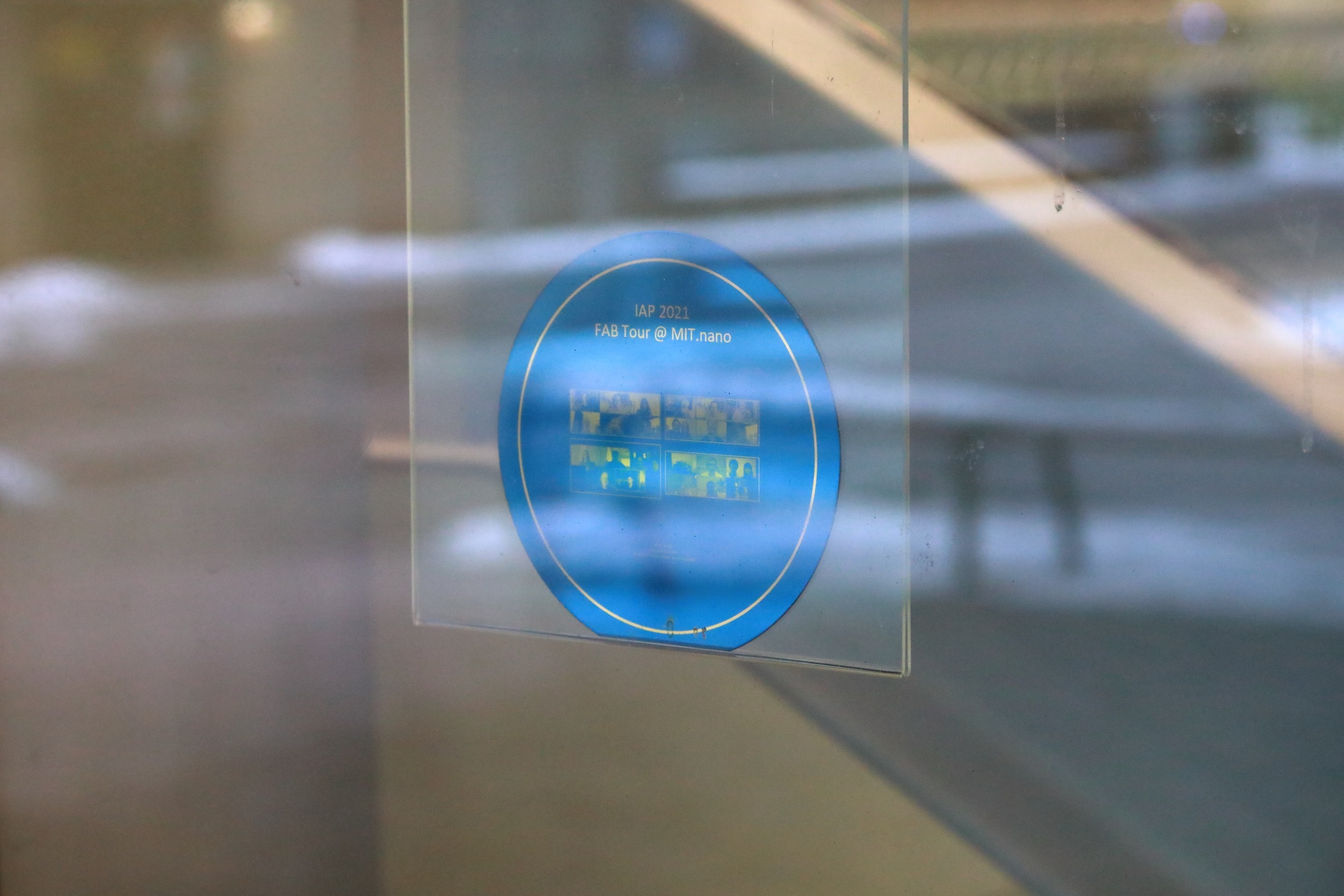 The final product, a silicon wafer fabricated at MIT.nano and etched with screenshots of the IAP participants, hangs in the West Lobby window at MIT.nano.