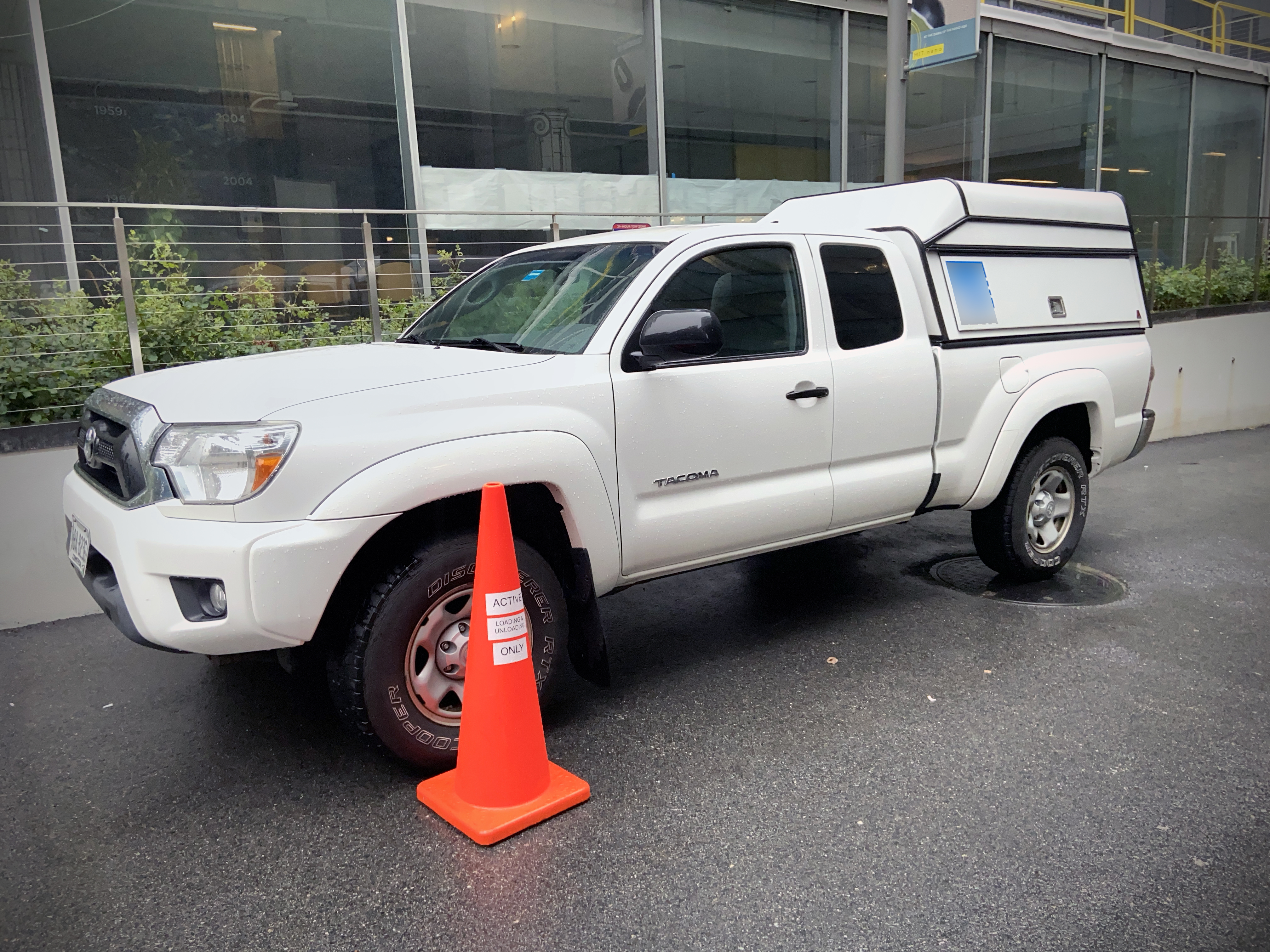 A commercial vehicle correctly marked at the MIT.nano loading dock with an orange cone.