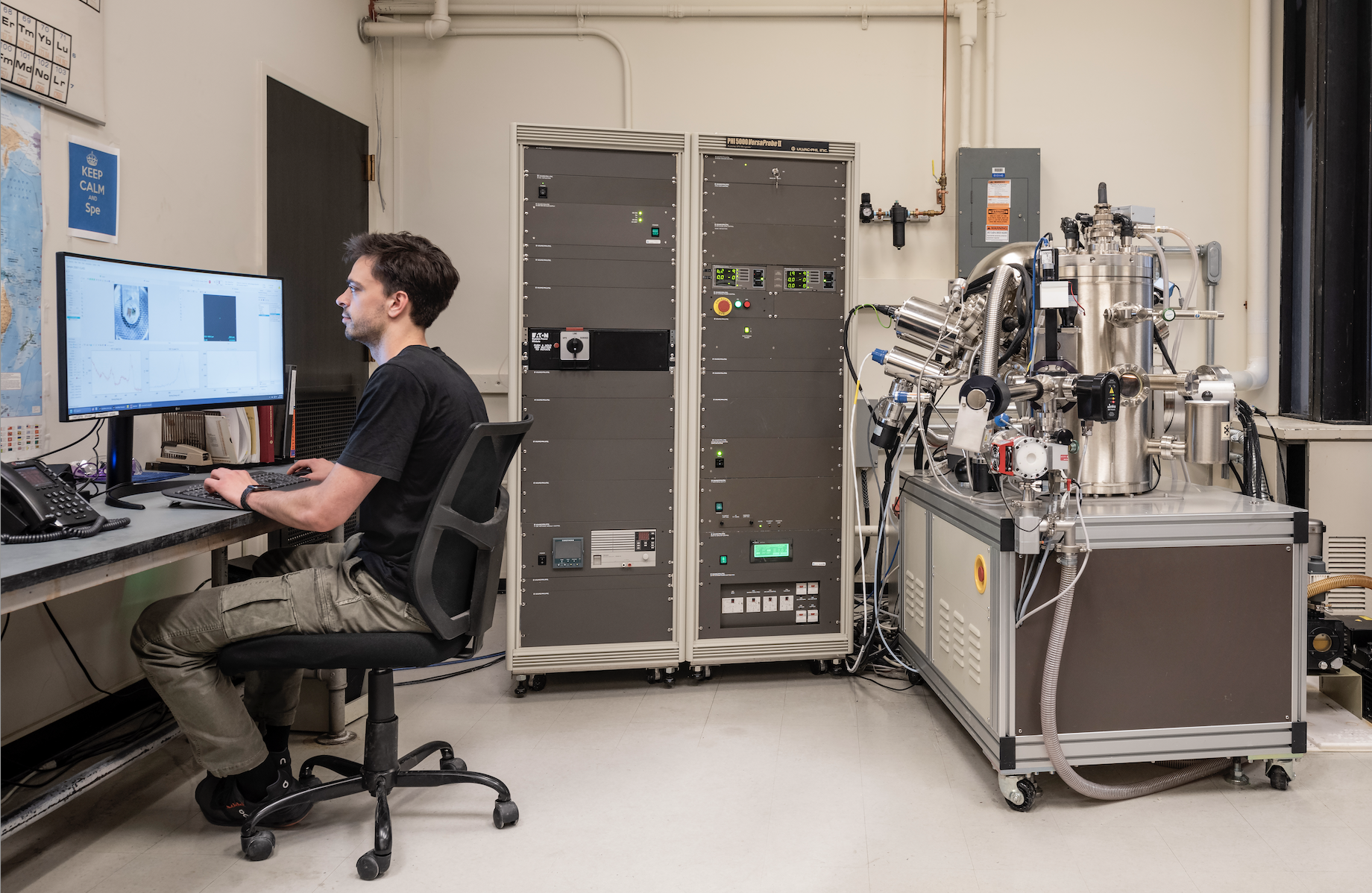 A person sitting at a computer with a spectrometer behind him.