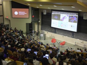 A professor speaks to a large audience