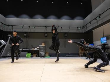 Three people dancing in motion capture suits