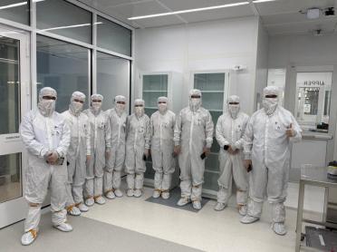 A line of people in bunny suits in a cleanroom