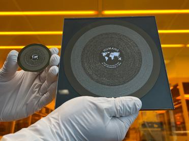 The 2-inch Humanity United with MIT Art and Nanotechnology in Space (HUMANS) wafer (left) landed on the moon March 6 aboard the Athena spacecraft. It is seen alongside its 6-inch counterpart, which flew to the International Space Station in 2023.